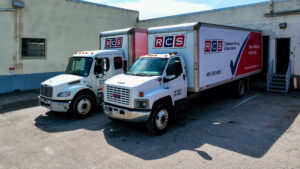 Two RCS Moving & Storage trucks parked at a loading dock, ready for service in Richmond, VA.