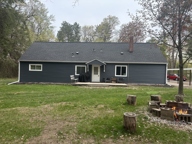 A rear view of a house showcasing new dark gray siding and roof installed by PMC Company in Brooklyn Park, MN.