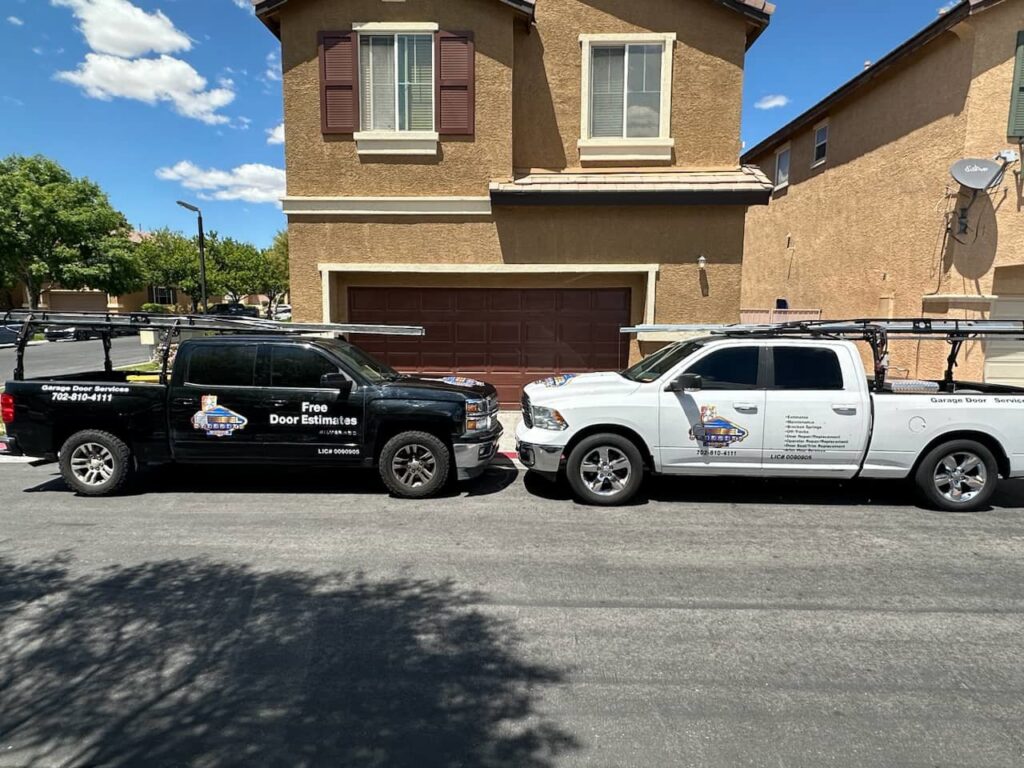 Two Rebel Overhead Doors service trucks parked in front of a house, ready for a garage door job in Las Vegas, NV.