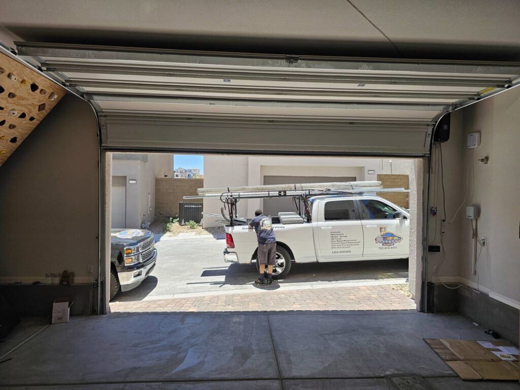 A Rebel Overhead Doors work truck parked outside a garage, indicating service at a job site in Las Vegas, NV.