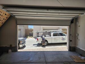 A Rebel Overhead Doors work truck parked outside a garage, indicating service at a job site in Las Vegas, NV.
