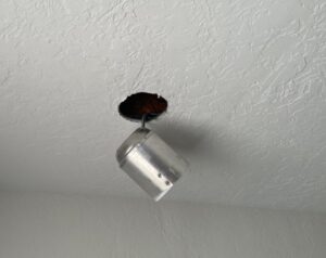 A recessed light fixture falling from a water-damaged ceiling, indicating structural issues addressed by RestoPros of Salt Lake City, UT
