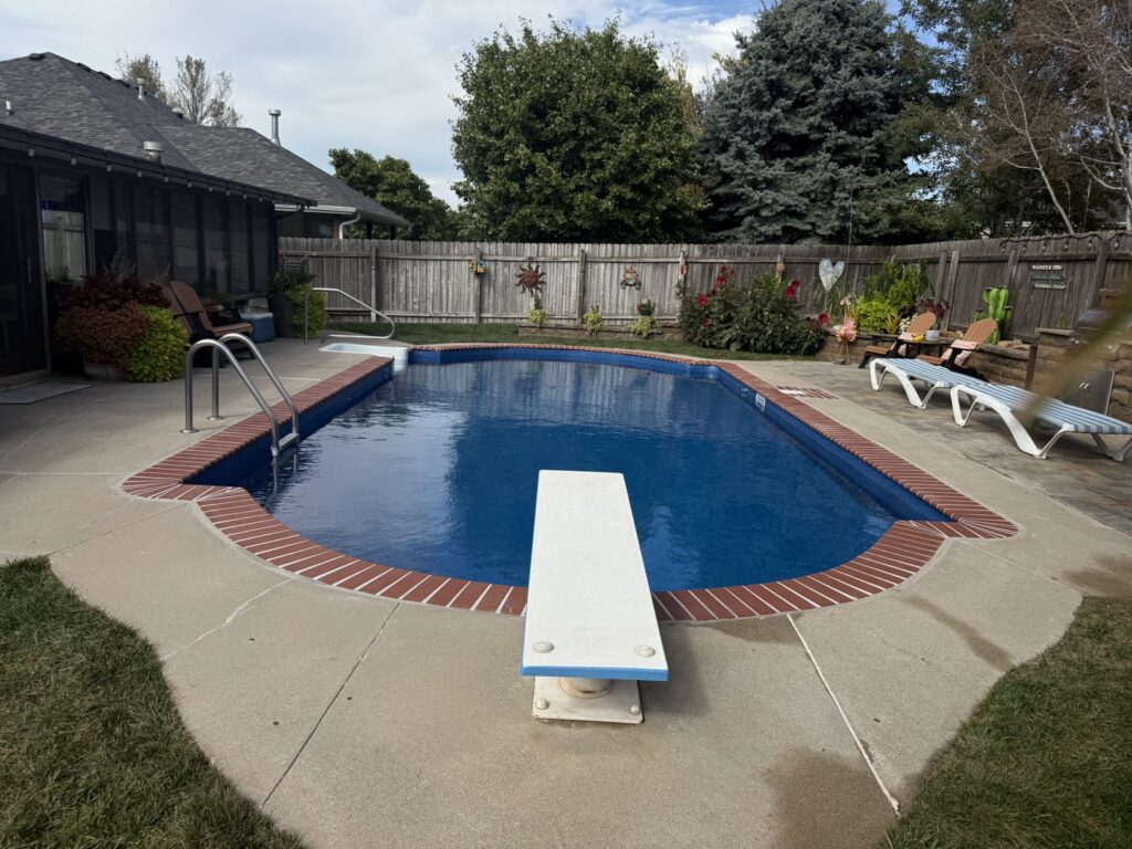 A completed rectangular swimming pool featuring a diving board and brick coping, built by Acapulco Pool and Spa LLC in Los Angeles, CA