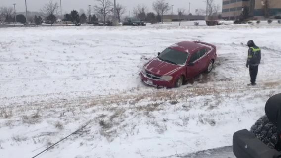 A red car stuck in deep snow, undergoing vehicle recovery by Towing Colorado in Colorado Springs, CO.
