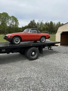 A red classic convertible car loaded onto a flatbed tow truck by Tow Truck Company in Johnson City, TN.