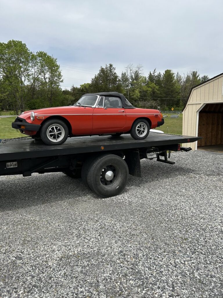 A red classic convertible car loaded onto a flatbed tow truck by Tow Truck Company in Johnson City, TN.