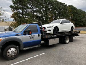 A red convertible sports car being transported on a flatbed tow truck by Hampton Roads Towing Services in Chesapeake, VA.