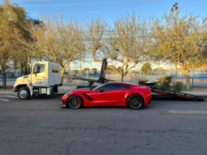 A red Corvette sports car being prepared for towing by Rojo's Towing in Phoenix, AZ.