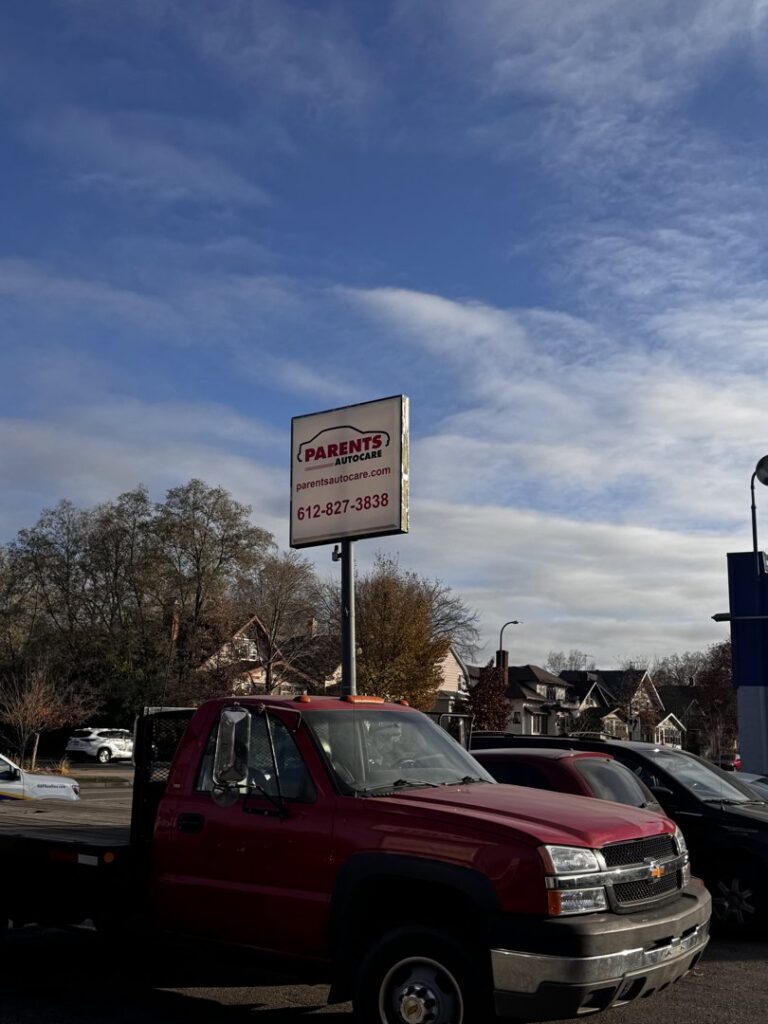 A red flatbed tow truck from Parents Autocare parked outside the business in Minneapolis, MN