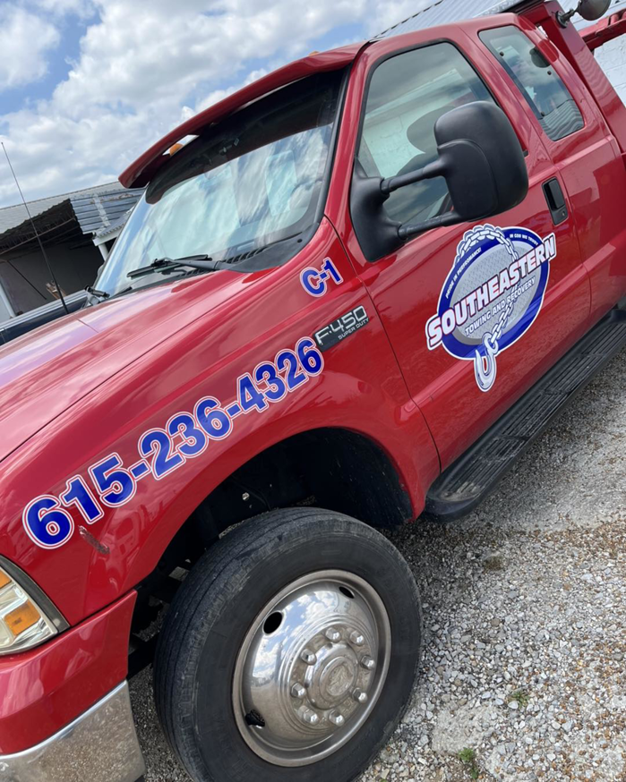 A red Ford F-450 tow truck, branded with Southeastern Towing Inc., ready for service in Chattanooga, TN.