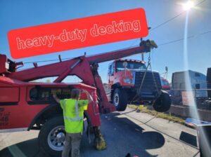 A red heavy-duty tow truck lifting the front of a large truck, demonstrating heavy-duty recovery services by JR's Services and Recovery, LLC in Indianapolis, IN.