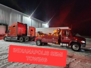 A red heavy-duty tow truck towing a semi-truck at night, providing Indianapolis semi towing services by JR's Services and Recovery, LLC in Indianapolis, IN.