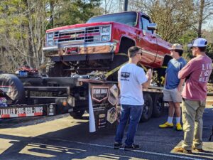 A red lifted truck secured on a flatbed trailer from B'ham Trailer Rentals in Alabaster, AL.