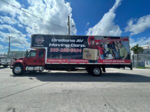 A branded red moving truck from Orellana AV Moving Corp. parked on a street in Miami, FL, ready for service.