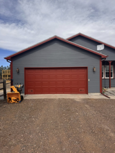 A red paneled residential garage door installed by Cowboy State Garage Doors, LLC in Cheyenne, WY.