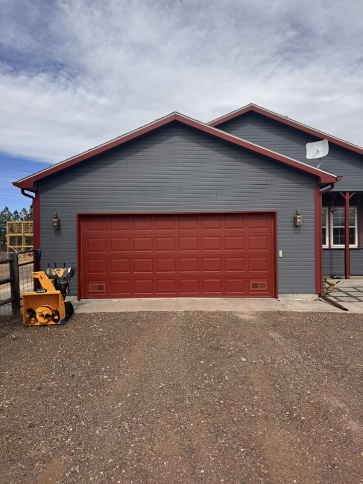 A red paneled residential garage door installed by Cowboy State Garage Doors, LLC in Cheyenne, WY.