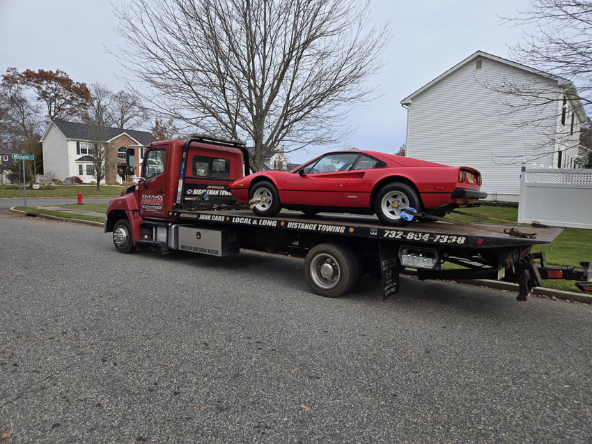 A red sports car being towed on a flatbed truck by Riggleman Towing in Moorefield, WV.