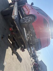 A red SUV being carefully loaded onto a flatbed tow truck by Tow & go in Louisville, KY.
