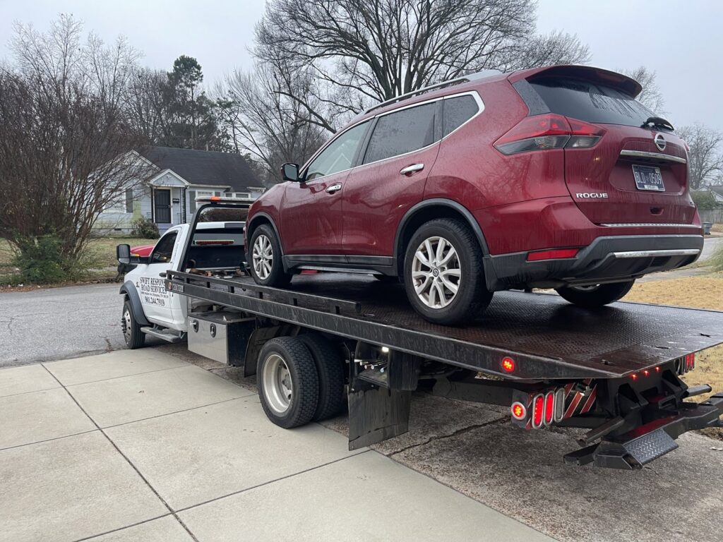A red SUV loaded onto a flatbed tow truck, providing towing services by Swift Response Road Services, LLC in Memphis, TN.