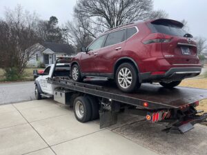 A red SUV loaded onto a flatbed tow truck, providing towing services by Swift Response Road Services, LLC in Memphis, TN.