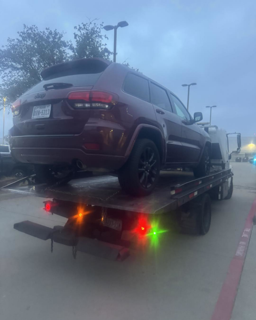 A red SUV loaded onto a flatbed tow truck for transport by Towing Near Me 247 LLC Dallas in Dallas, TX.