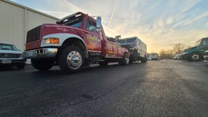 A red tow truck from Terry's Auto Service and Towing, LLC, towing a large white box truck in Springfield, MO.