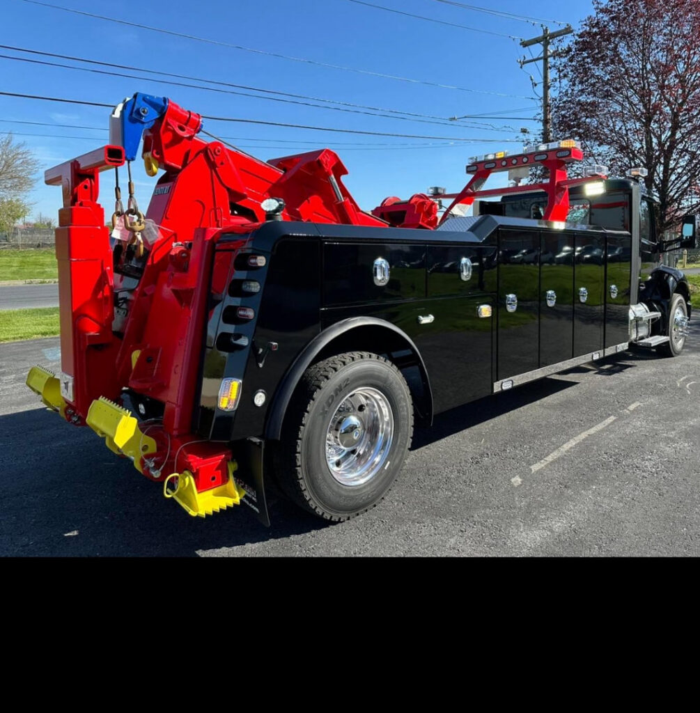 A red wrecker tow truck from Hank's Auto Service towing a white truck in Bethlehem, PA.