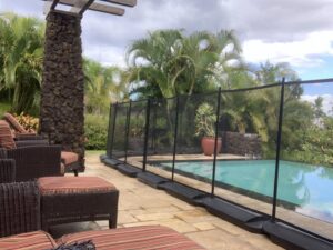 A removable pool fence with weighted bases installed by Guardian Pool Fence Systems of Hawaii, providing safety around a pool in Honolulu, HI.