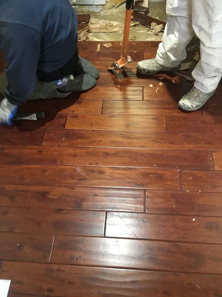 PuroClean technicians removing damaged hardwood flooring during water damage restoration in Northport, AL.