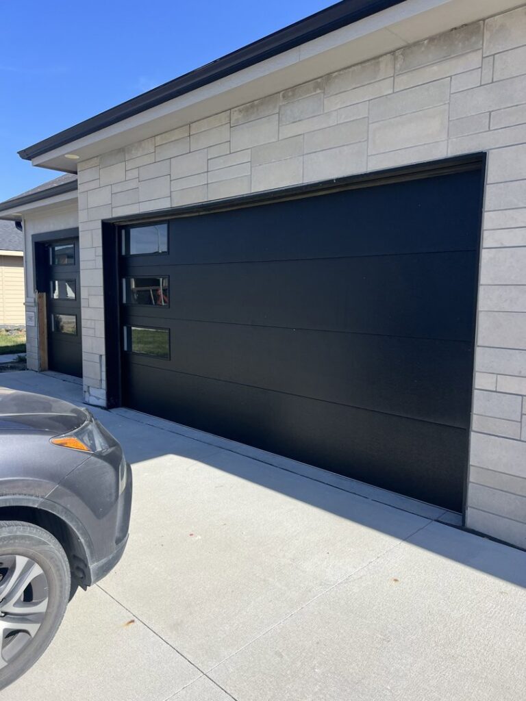 A newly installed black modern residential garage door by Garage Door Services, Inc. in Omaha, NE.