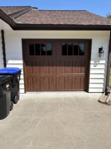 A newly installed residential brown garage door with windows by Woodwards Overhead Door Co. in Topeka, KS