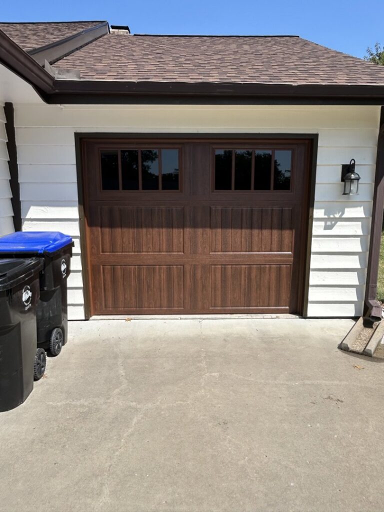 A newly installed residential brown garage door with windows by Woodwards Overhead Door Co. in Topeka, KS