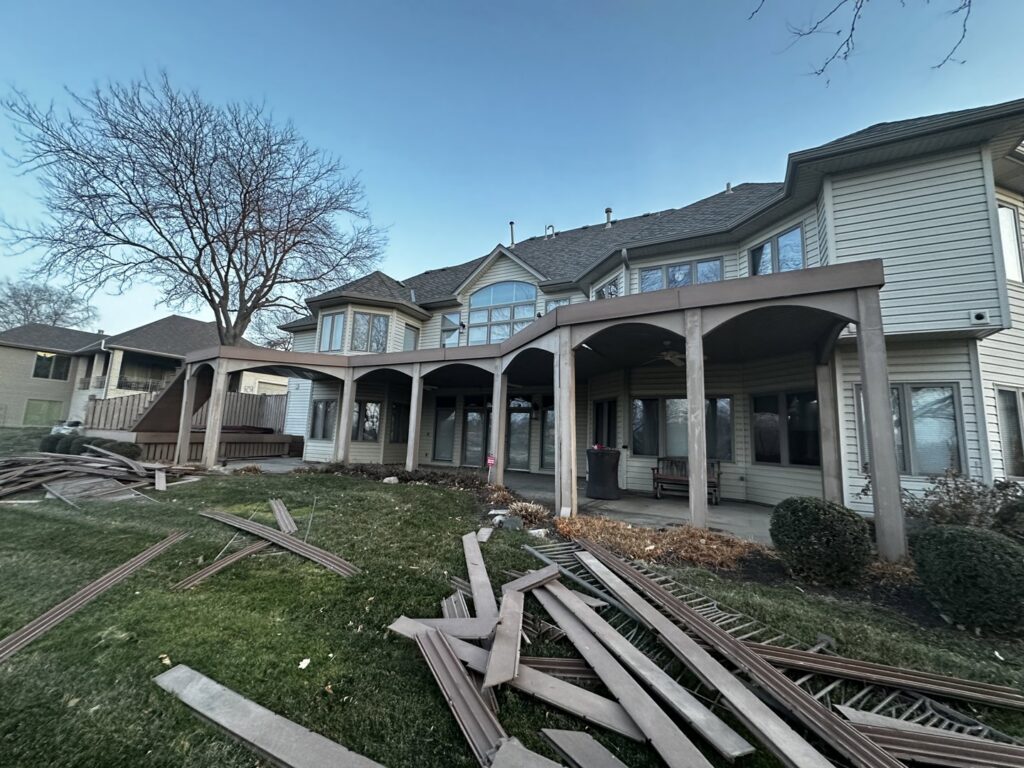 Residential deck demolition with debris scattered on the ground by Allis Demolition & Hauling LLC in Omaha, NE