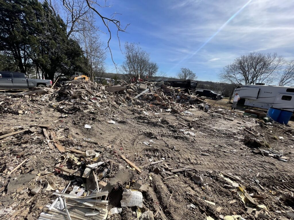A large pile of residential demolition debris on a dirt lot after a structure removal by Vaquero Demolition in Lewisville, TX.