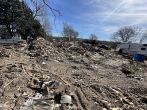 A large pile of residential demolition debris on a dirt lot after a structure removal by Vaquero Demolition in Lewisville, TX.