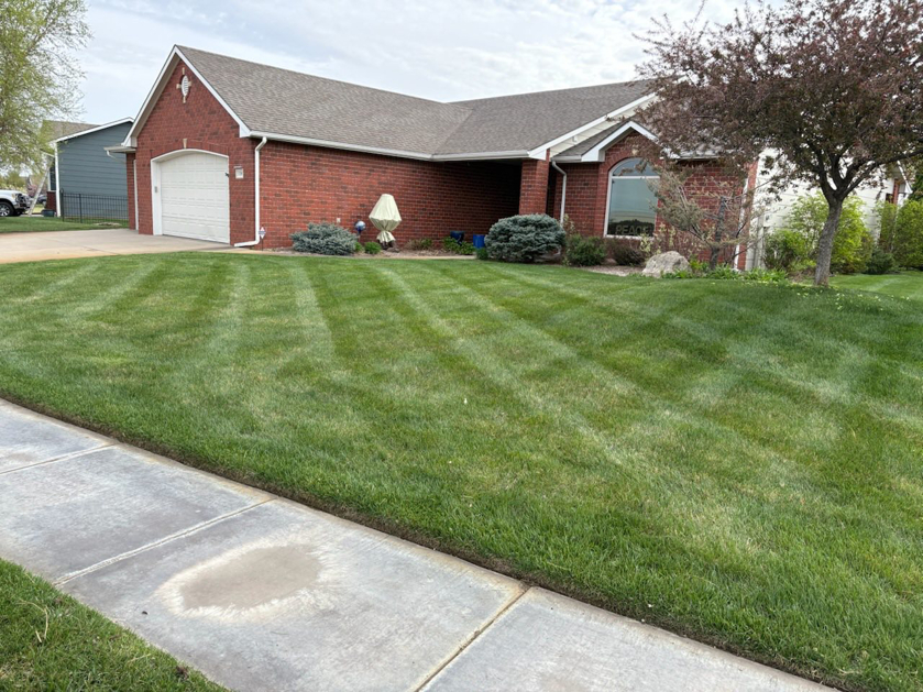 Residential front lawn with neatly mowed grass and straight stripes by EZ Cut Lawn Care & Landscaping, Crestview, FL.