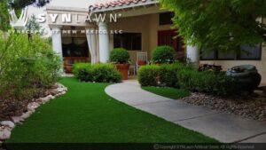 A beautifully landscaped residential front yard with artificial grass installed by SYNLawn of New Mexico in Albuquerque, NM.