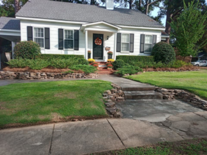 A well-maintained residential front yard with trimmed hedges and pine straw by Turner Lawn Care in Tupelo, MS.