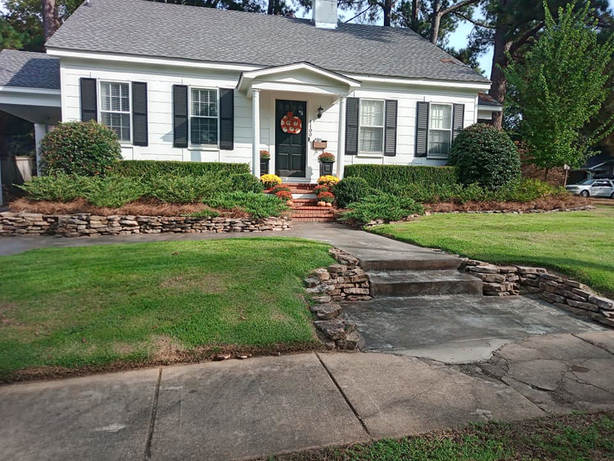 A well-maintained residential front yard with trimmed hedges and pine straw by Turner Lawn Care in Tupelo, MS.