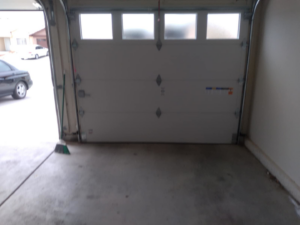 A white residential garage door with top windows, partially open, installed by Cactus Garage Doors, Inc. in North Las Vegas, NV.