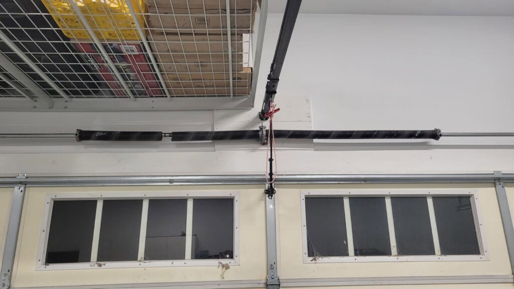 Interior view of a residential garage door with torsion spring and windows, showing components serviced by Right Choice Doors in Layton, UT.