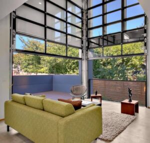 Residential glass garage doors opening to an outdoor living space by Valley Overhead Door in Las Vegas, NV.