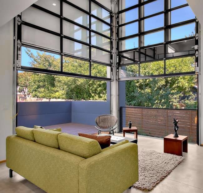 Residential glass garage doors opening to an outdoor living space by Valley Overhead Door in Las Vegas, NV.