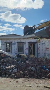 An excavator performing residential house demolition, creating a pile of debris for Allied Wrecking Boston in East Boston, MA.