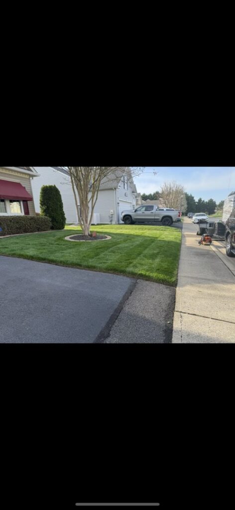 A residential lawn with precise edging along the driveway, showcasing the detailed work of A & J Lawn Care LLC in Corsicana, TX.