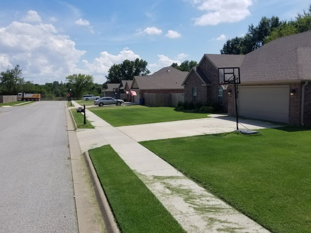 A residential street with neatly mowed lawns showing professional lawn care by Full Throttle landscapes and lawn care in Port Orchard, WA.