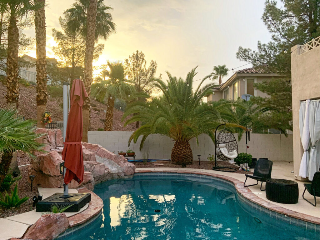 A residential swimming pool with a pool vacuum in the water, indicating professional cleaning by Priority Pools LV in Las Vegas, NV