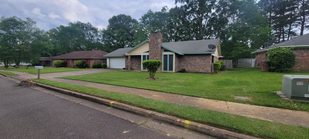 A residential property featuring a neatly trimmed and freshly mowed lawn by Caffey's Lawn Care LLC in Jackson, MS.