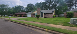 A residential property featuring a neatly trimmed and freshly mowed lawn by Caffey's Lawn Care LLC in Jackson, MS.