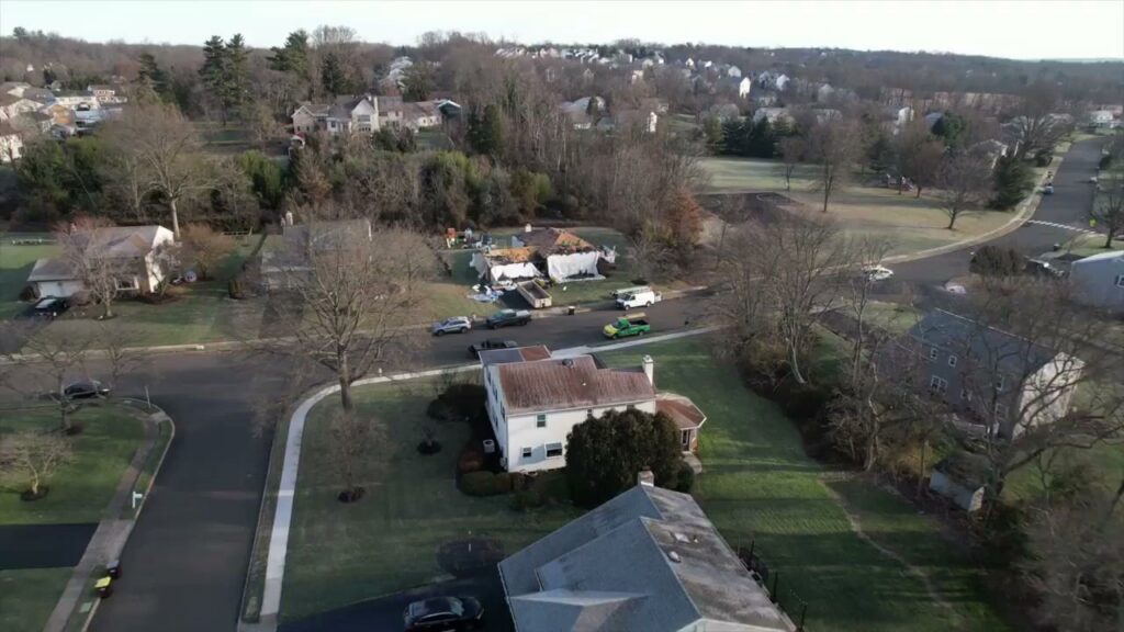 An aerial view of a residential roof repair project in progress by PJ Fitzpatrick LLC in New Castle, DE, addressing potential water damage.